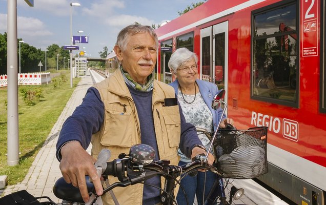 Ein älteres Paar möchte mit 2 Fahrrädern in einen Zug einsteigen