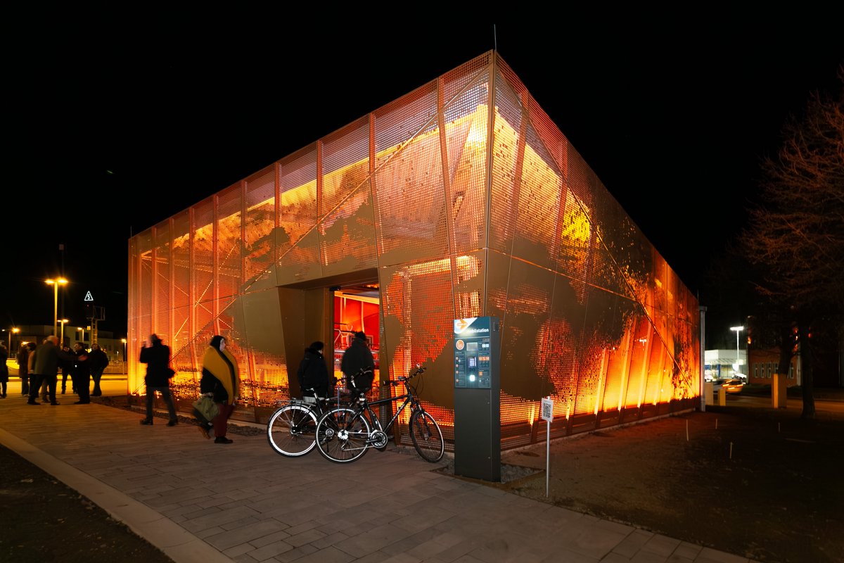 Das neue Fahrradparkhaus begrüßt die Menschen am Bedburger Bahnhof mit einer künstlerisch gestalteten und in den Abendstunden beleuchteten Fassade. © Hannes Keßler, Stadt Bedburg Das neue Fahrradparkhaus begrüßt die Menschen am Bedburger Bahnhof mit einer künstlerisch gestalteten und in den Abendstunden beleuchteten Fassade. © Hannes Keßler, Stadt Bedburg