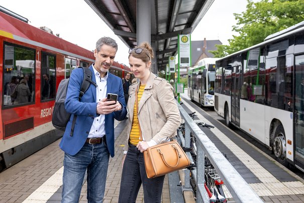 Pärchen an Bahnhalt mit Busanschluss