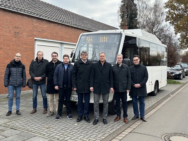 Bus- und Bahnverkehr in Zülpich: Vertreter des Landrats, der Bürgermeister und Vertreter der Verkehrsunternehmen posieren vor einem Bus.
