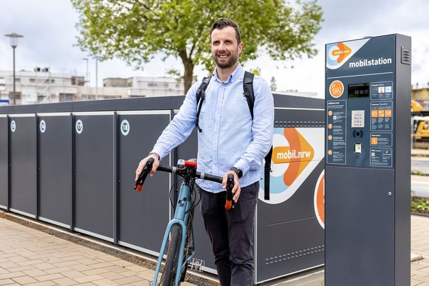 Das Bild zeigt einen Radfahrer, der sein Fahrrad an einer Mobilstation abholt (© go.Rheinland / Smilla Dankert)